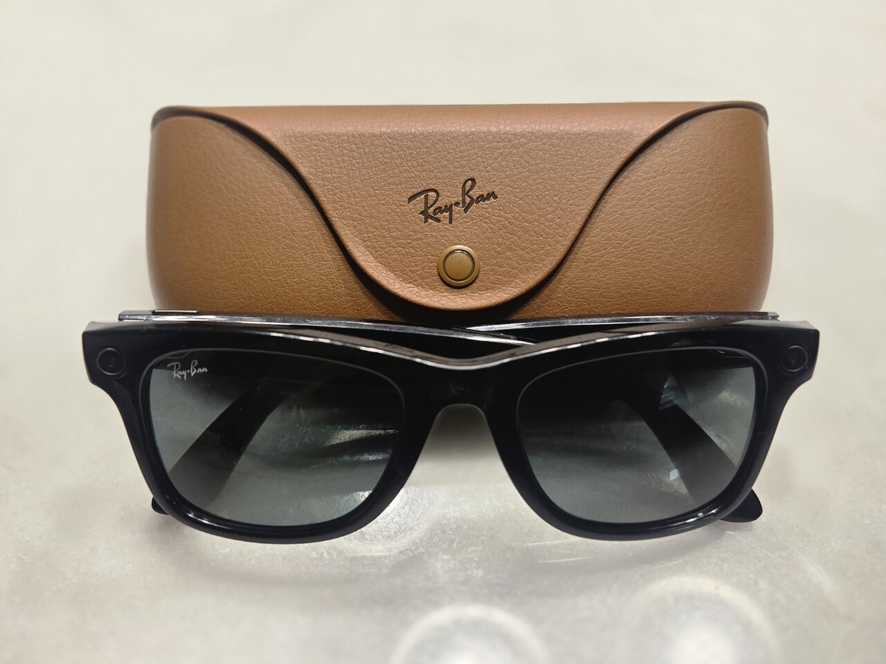 Zwarte Ray-Ban Meta smart glasses naast de oplaadcase