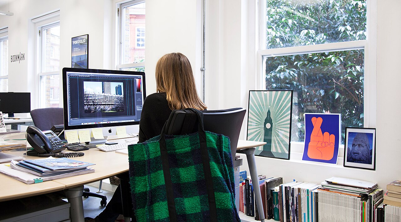 Une employée assise à son bureau, concentrée sur son travail devant un ordinateur
