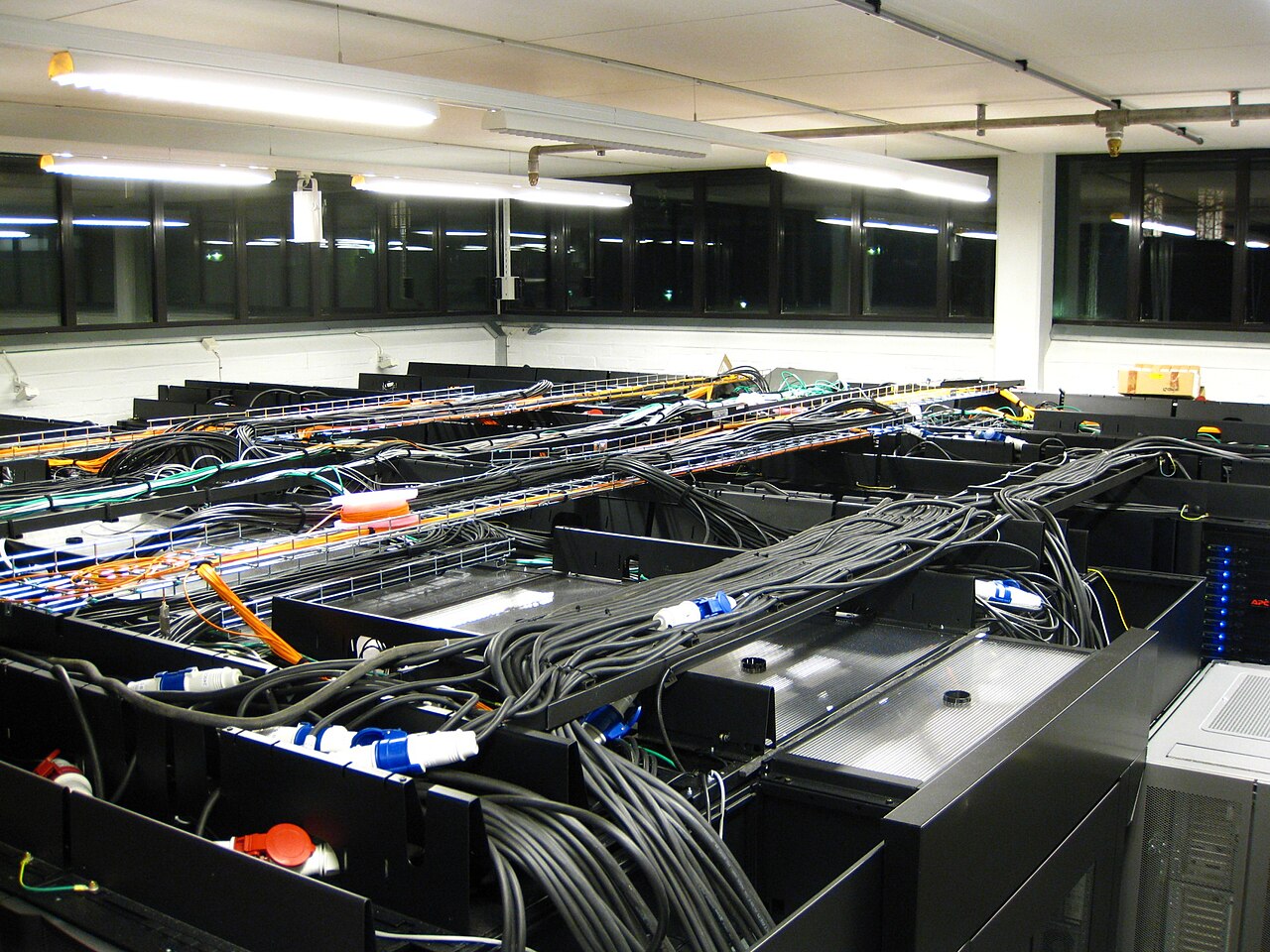 A server room with racks and fiber-optic network cabling