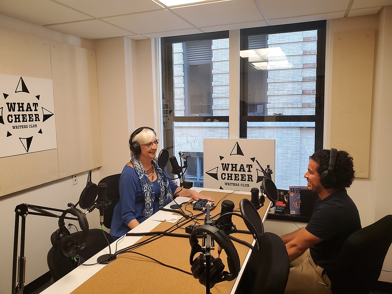Un studio de podcast avec plusieurs micros et des personnes qui discutent
