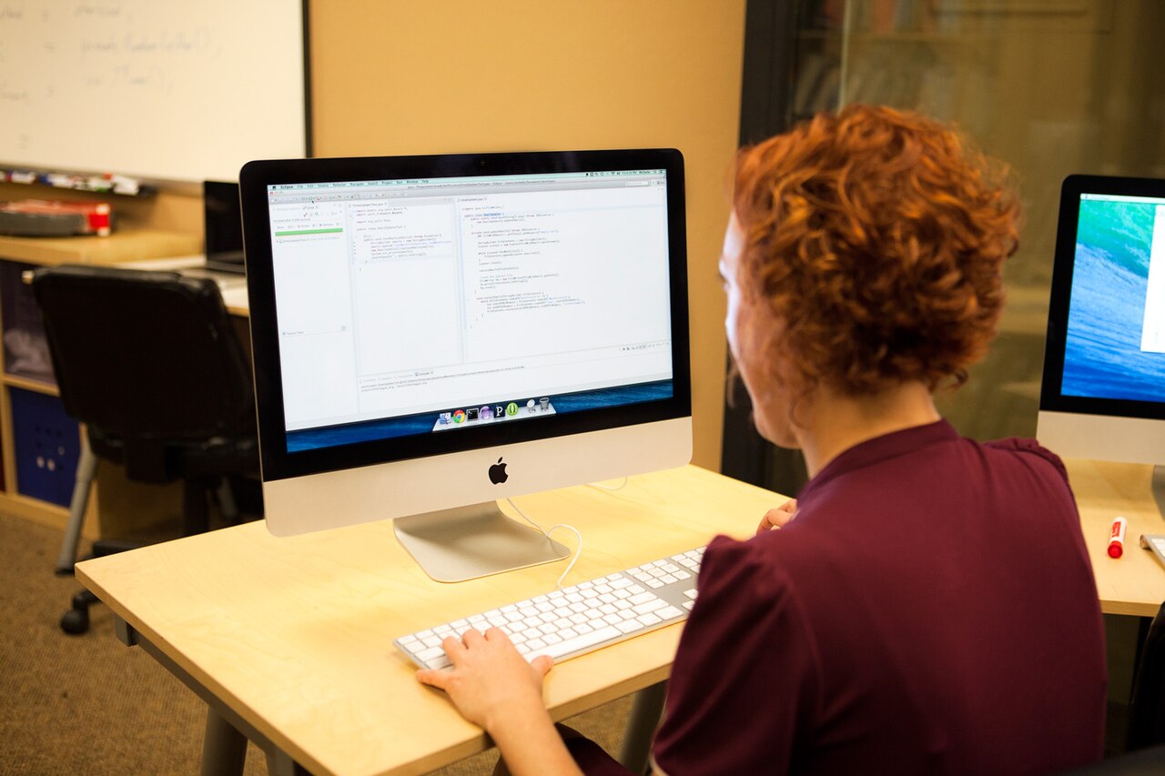 A software developer writing and testing code on a computer