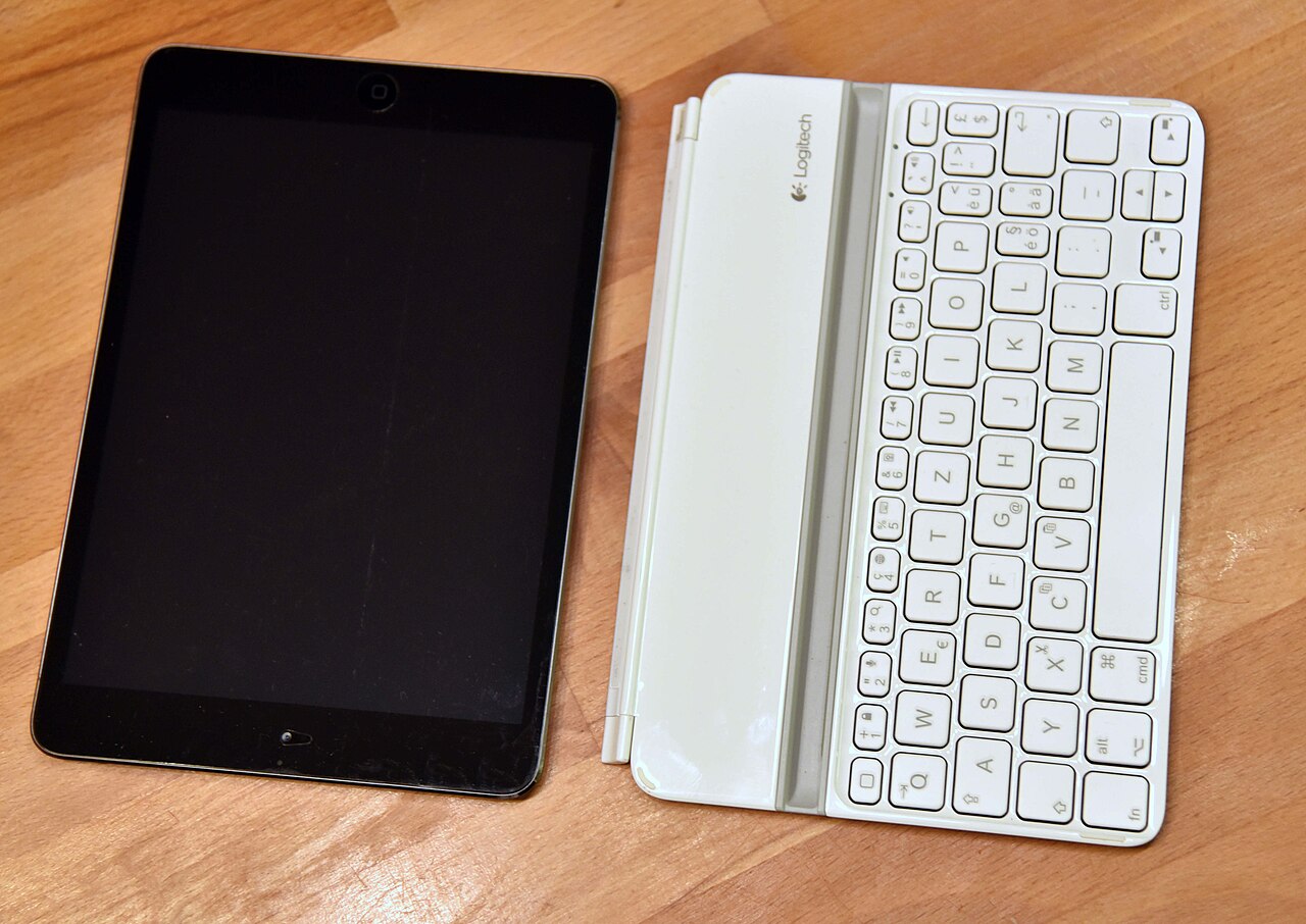 Une tablette Apple iPad mini repose sur une surface en bois.