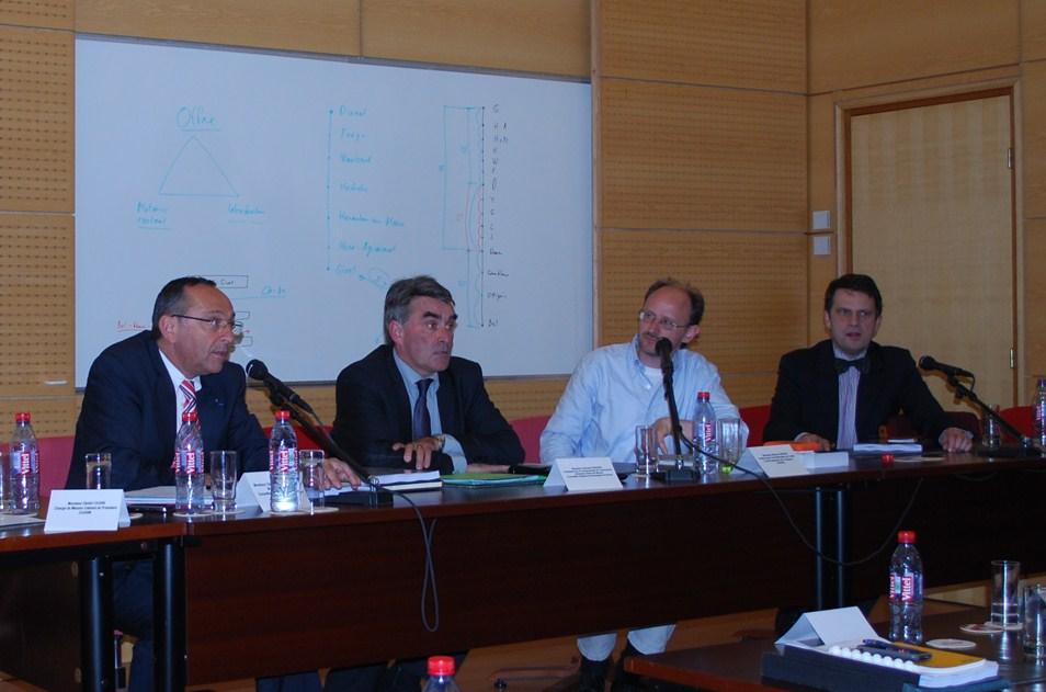 Vier Teilnehmer sitzen während einer Podiumsdiskussion hinter Mikrofonen.