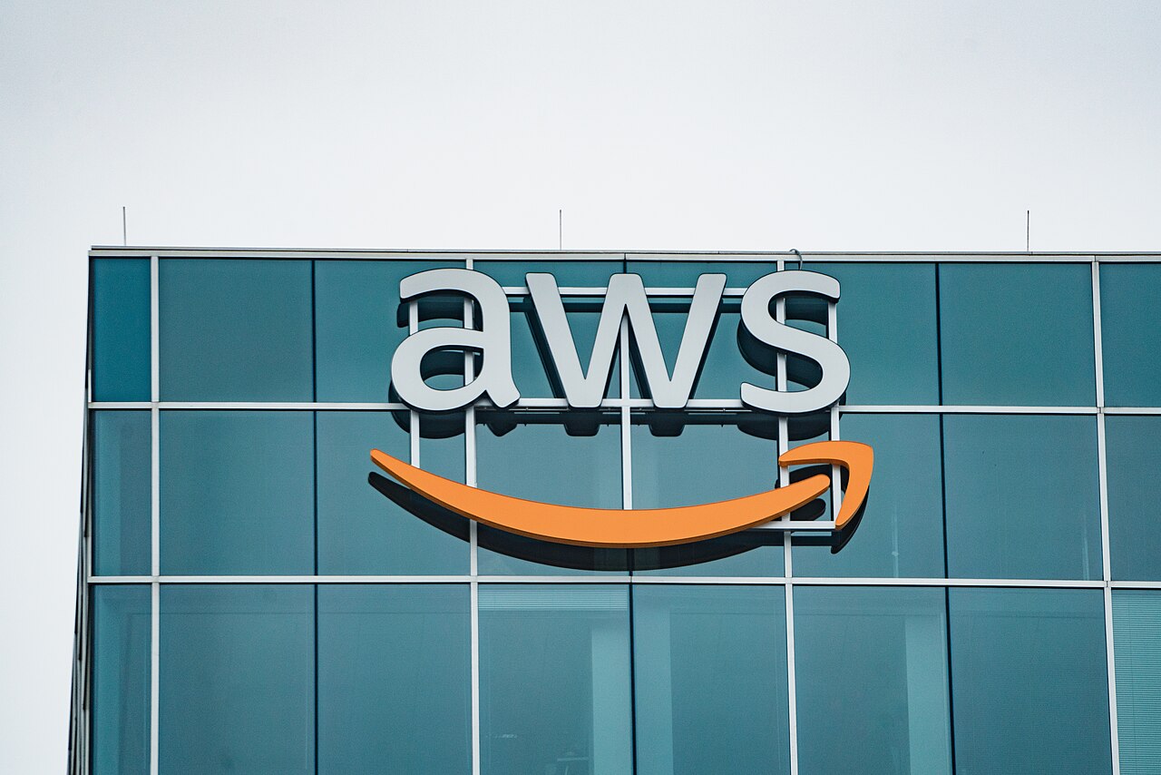 L'extérieur d'un bâtiment d'Amazon Web Services situé à Houston, Texas, avec une façade moderne et le logo AWS visible.