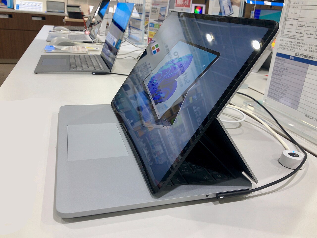 Un Microsoft Surface Laptop Studio est ouvert sur un présentoir à l'intérieur d'un magasin.