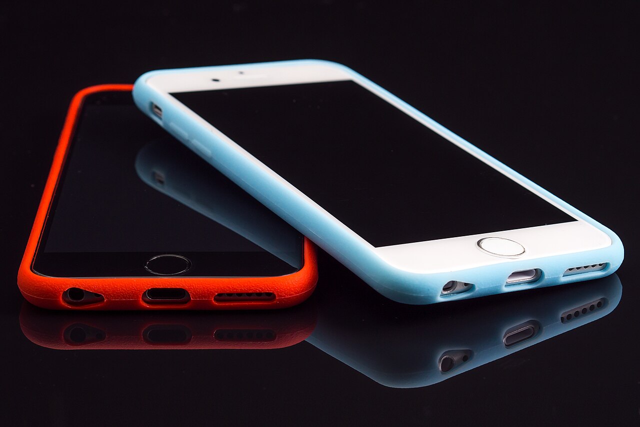 Deux iPhone posés côte à côte sur une table en bois