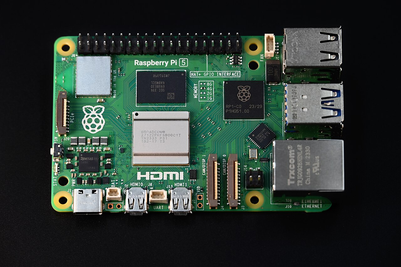 Primer plano de una Raspberry Pi 5 verde, computadora de placa única, sobre fondo negro.