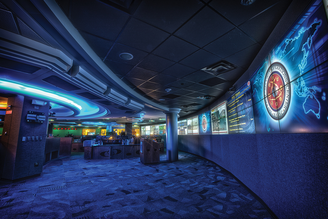 The monitoring floor of a national cybersecurity operations center, with rows of screens showing real-time security data